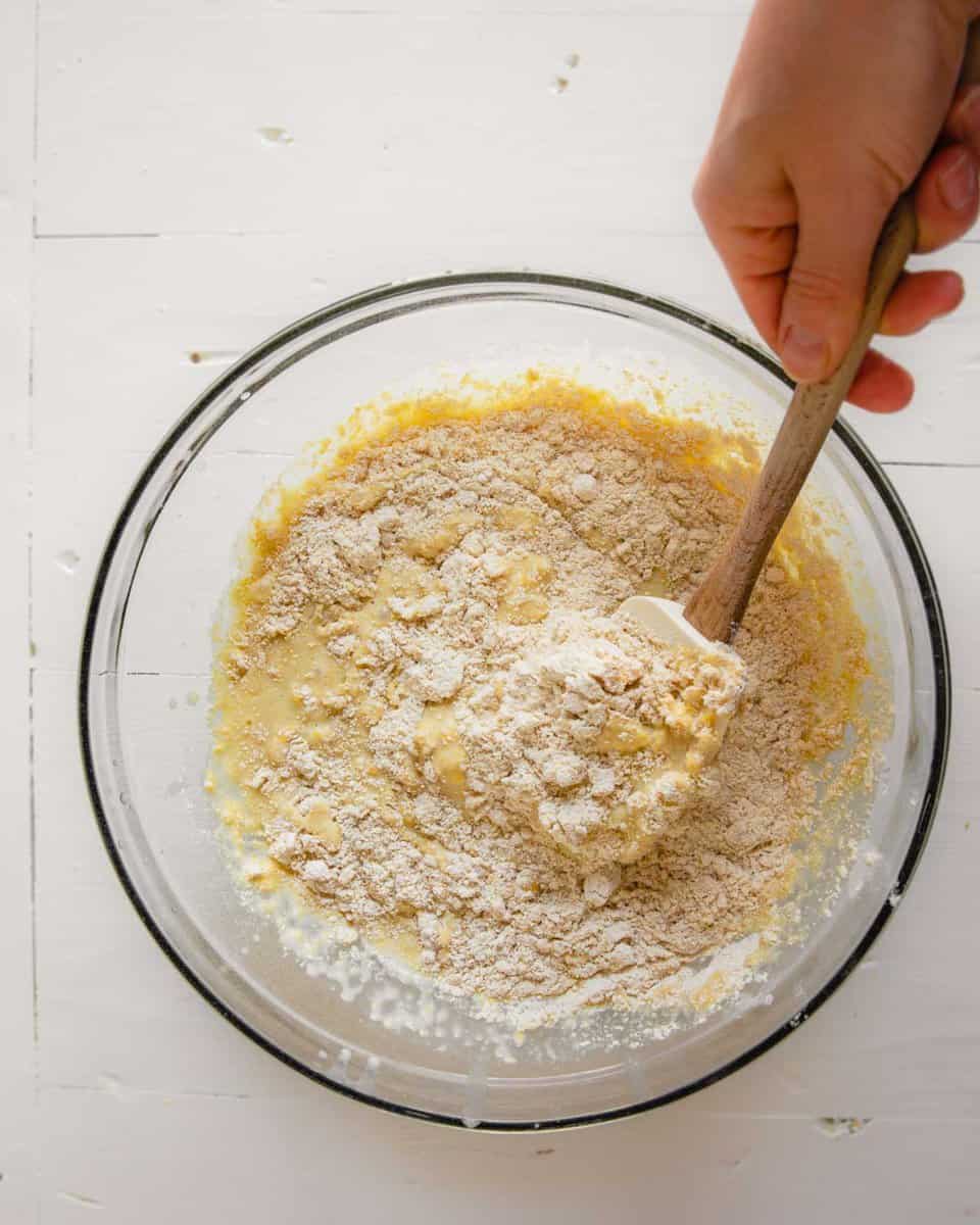 Overhead photo of wet ingredients being mixed into dry ingredients for healthy cornbread