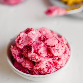 side angle of a bowl of pink-hued butter piled into it