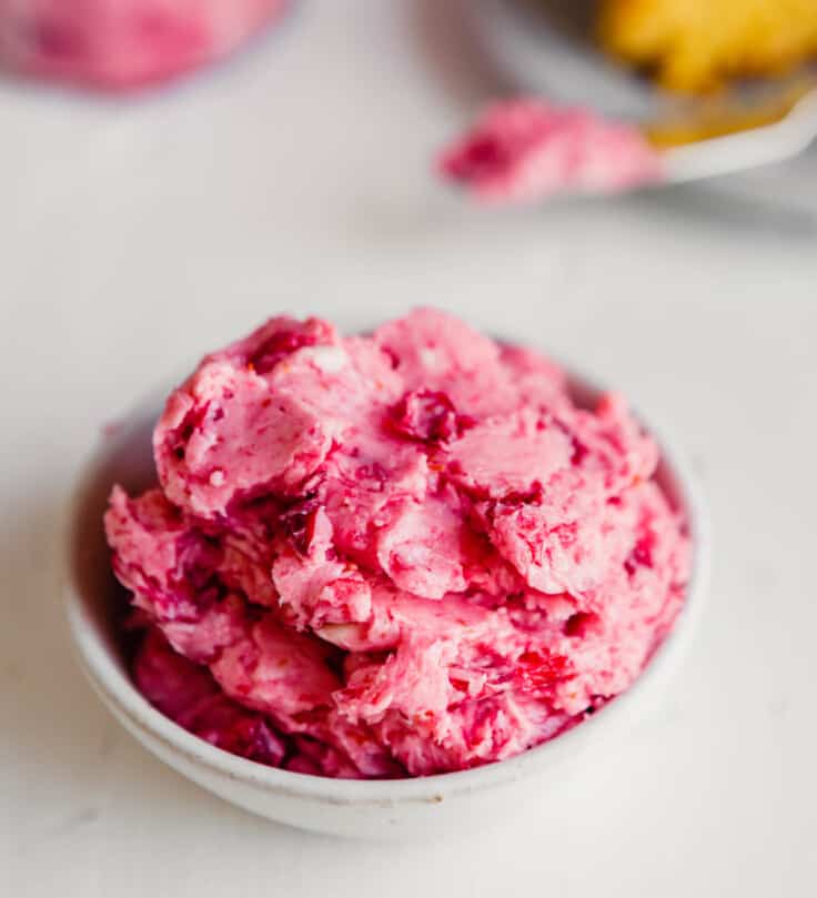 side angle of a bowl of pink-hued butter piled into it