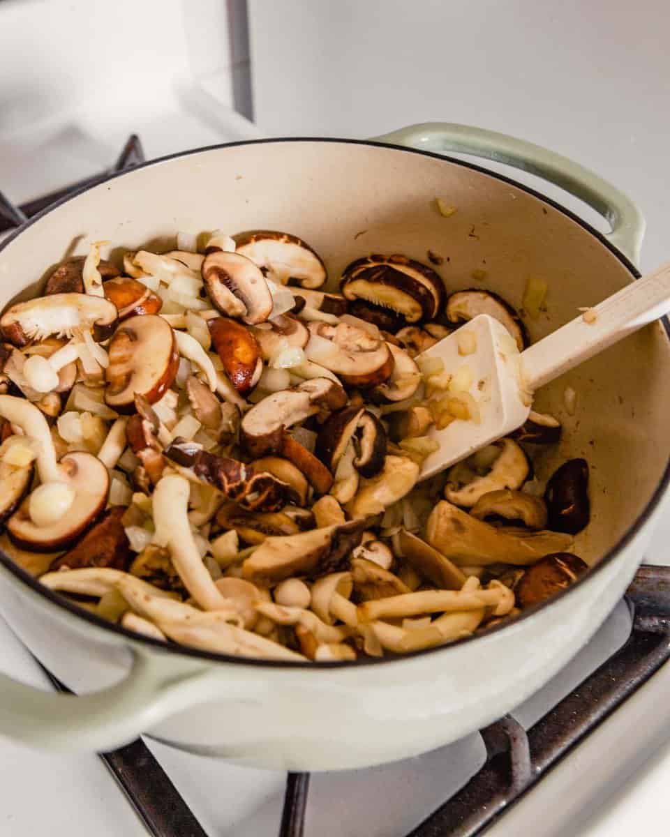 Fresh cut mushrooms in a pot with onions