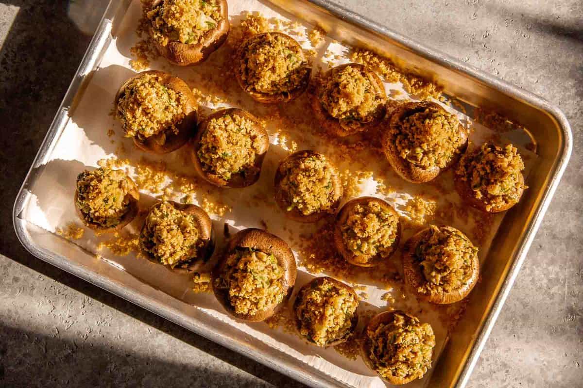stuffed mushrooms on a parchment lined baking sheet.