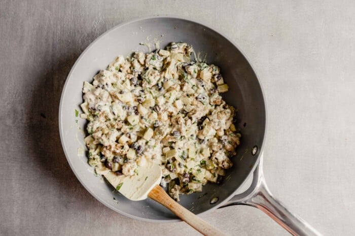 creamy turkey and veggie filling in a gray skillet set on a gray table
