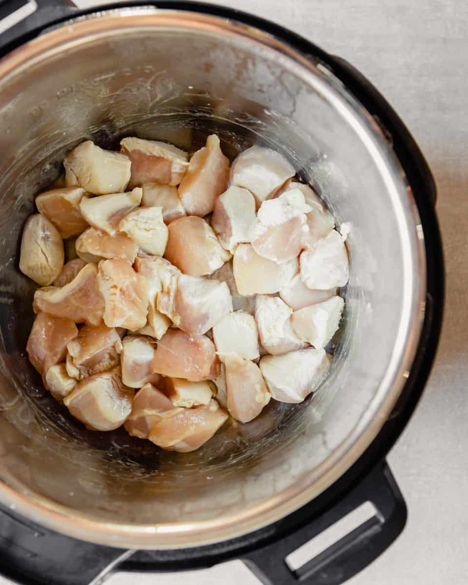 overhead image of chunks of chicken breast being seared in an instant pot