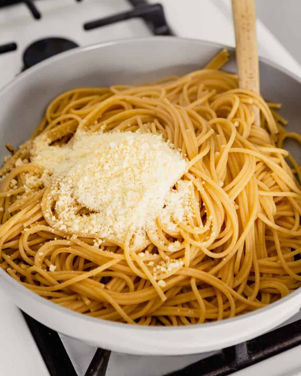 noodles and parmesan in a gray skillet on a stove