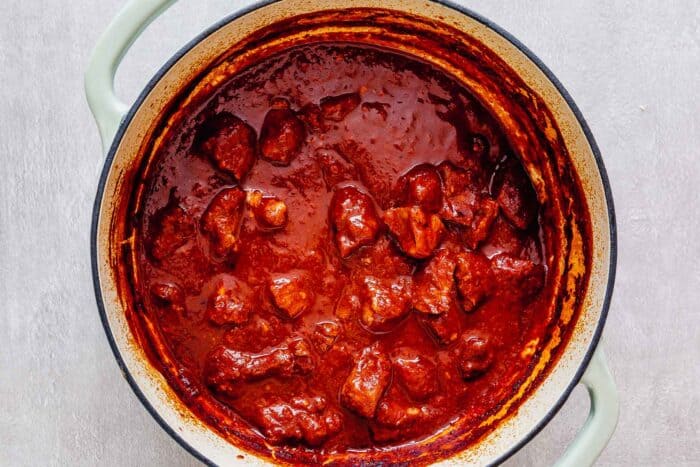 braised chunks of pork in a rich chile sauce in a dutch oven