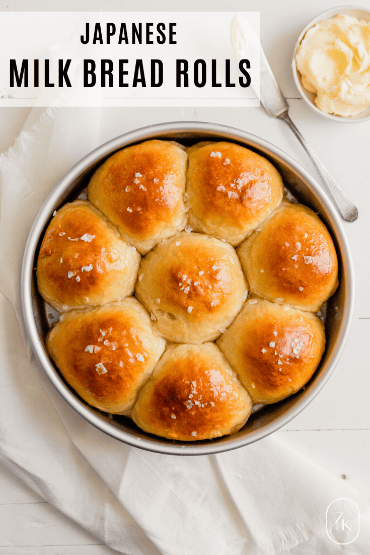 Overhead image of milk rolls in a round cake pan set on a white table