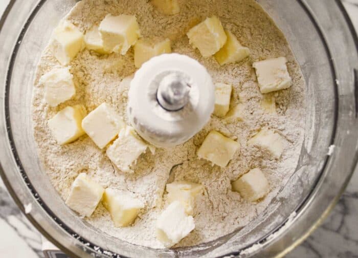 cubes of butter on top of flour in a food processor