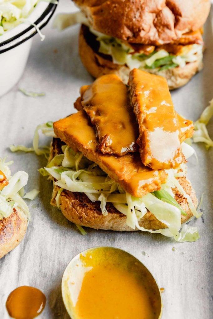barbecued tempeh pieces arranged over slaw on a whole wheat bun