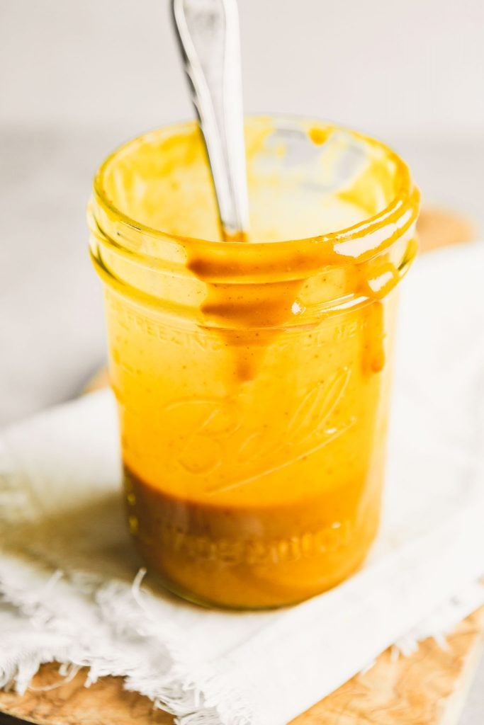 a quarter of a glass jar filled with yellow sauce