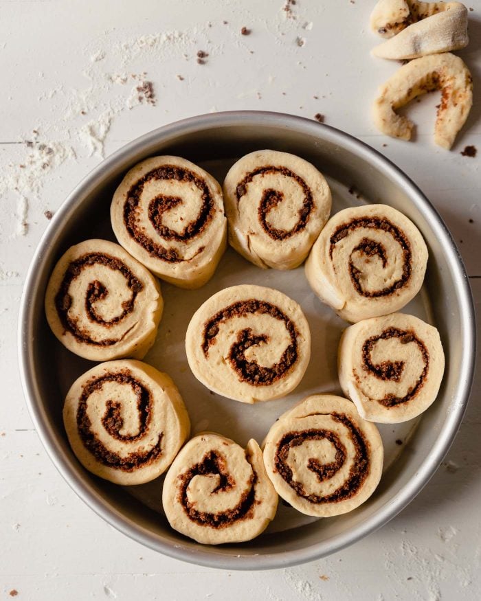 image of unbaked cinnamon rolls in a round cake pan