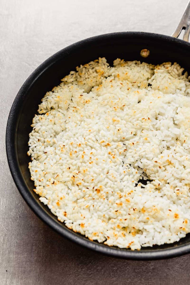rice in a single layer in a baking sheet, lightly golden brown