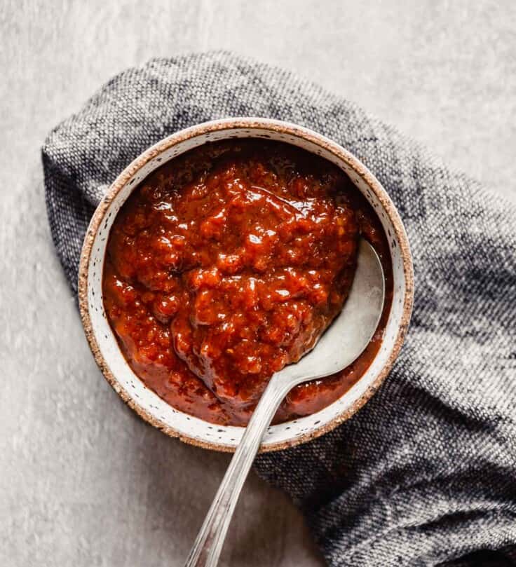 image of a red sauce in a bowl set on top of a gray napkin