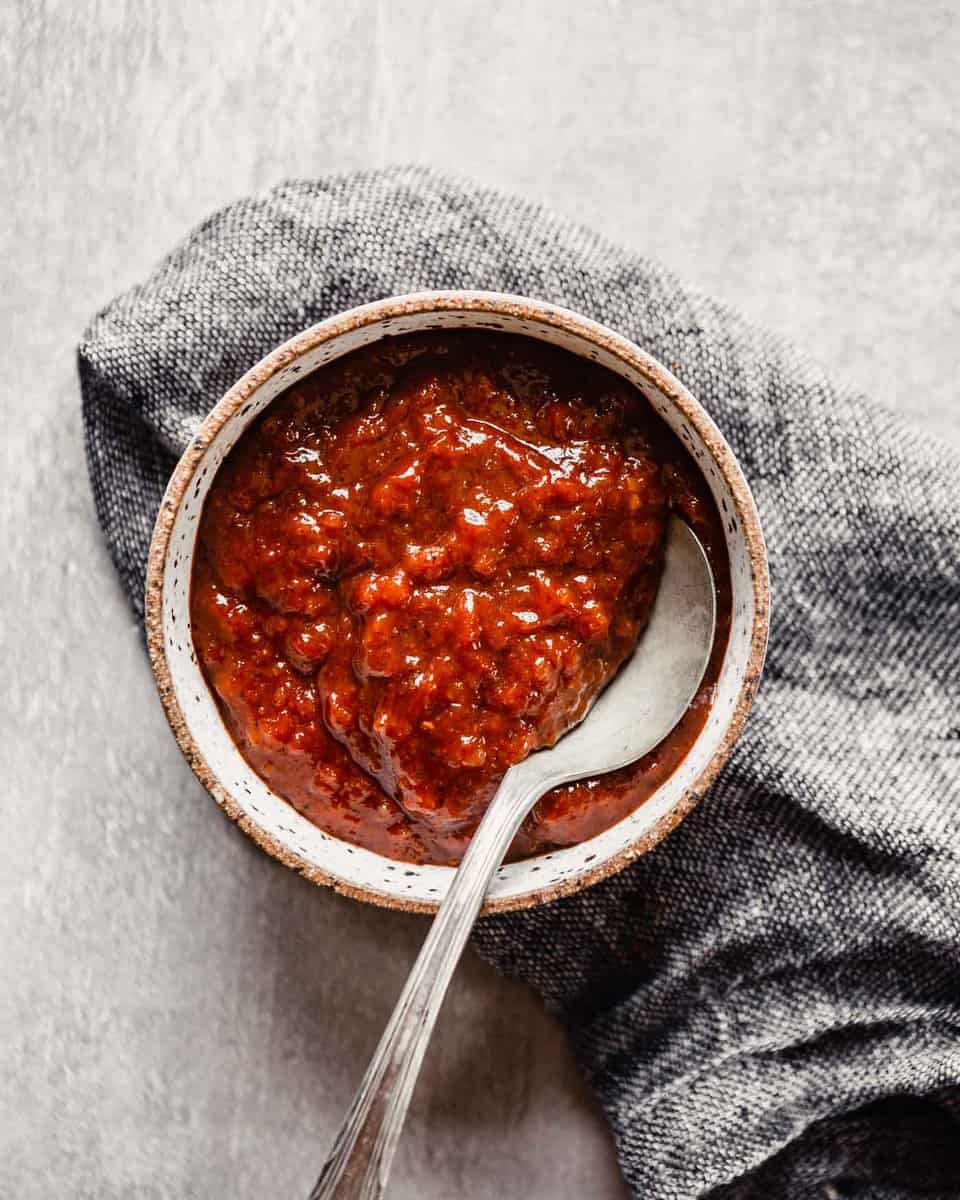 image of a red sauce in a bowl set on top of a gray napkin