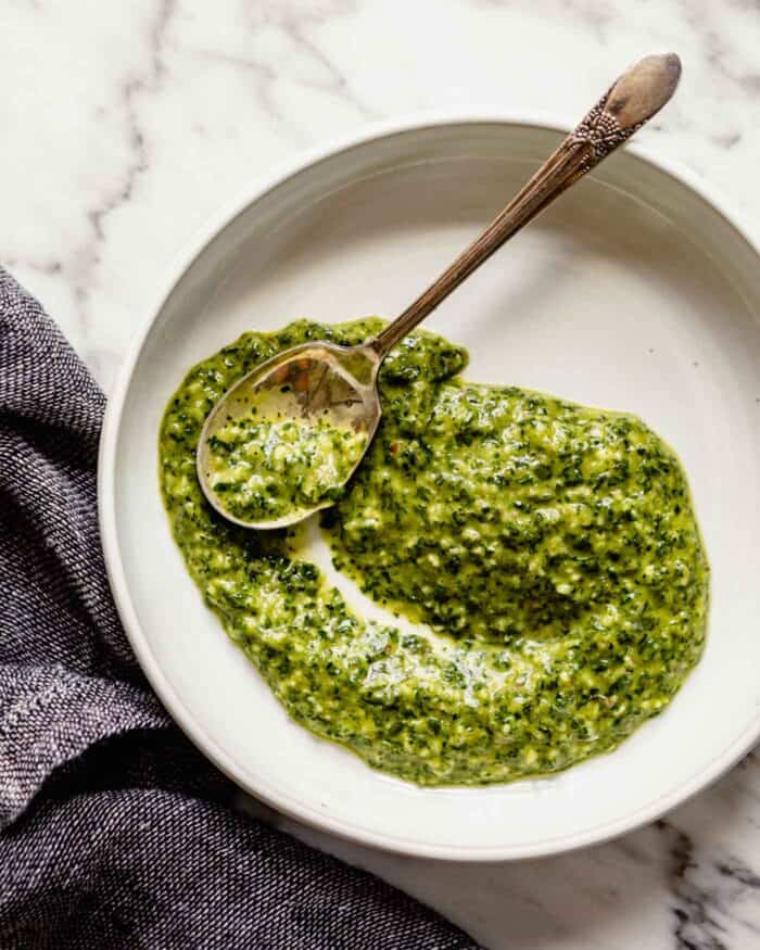 image of a green sauce spread across a shallow white bowl.