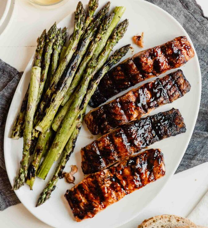 glazed salmon fillets on a plate with grilled asparagus