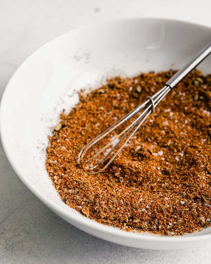 spice blend in a white bowl with a small whisk