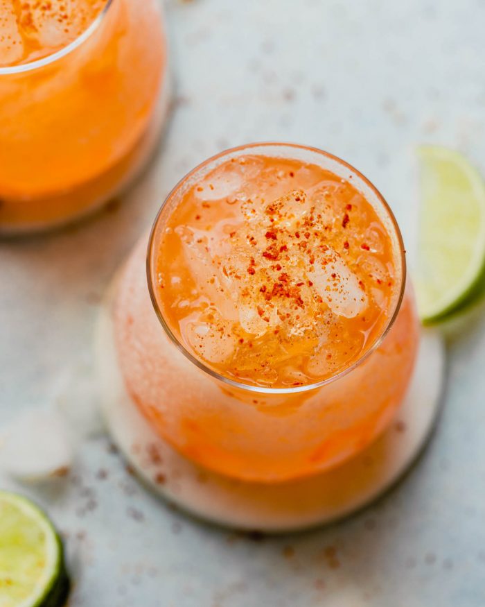 orange colored aperol margarita  in a rocks glass filled with crushed ice