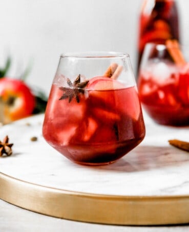 photography of a Red wine apple sangria set on a white marble tray