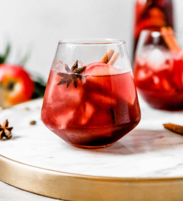 photography of a Red wine apple sangria set on a white marble tray