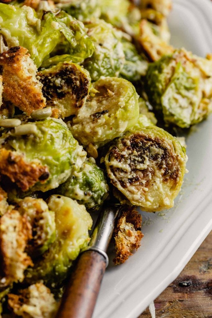 Close up image of a roasted brussel sprout tossed in caesar dressing