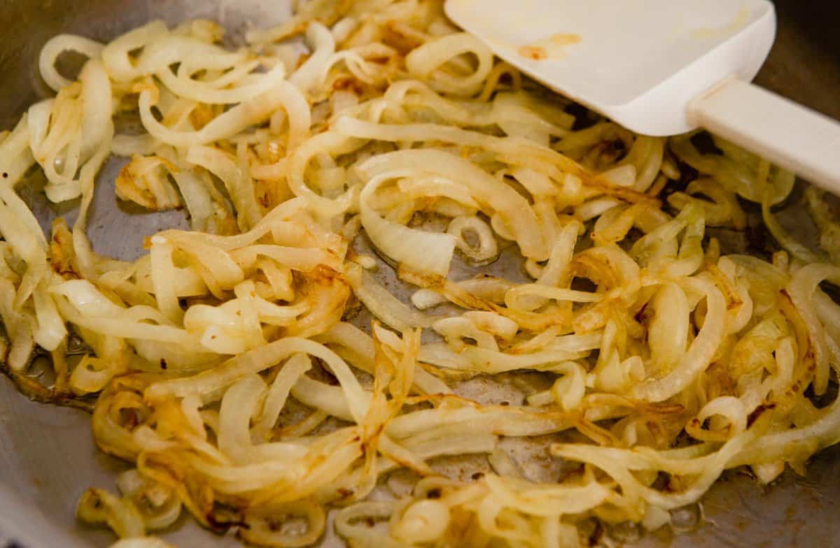 thin slices of onion cooking in a skillet