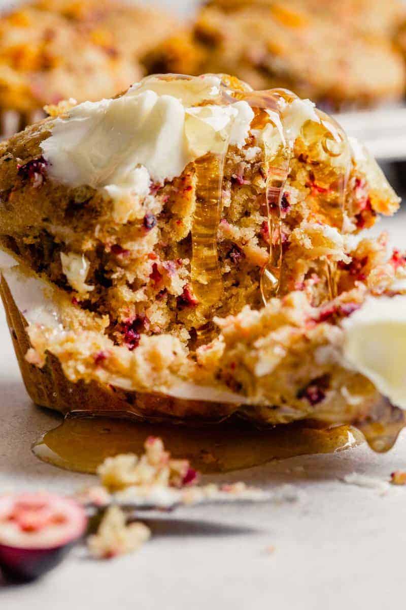 cranberry muffin topped with butter and drizzled with honey