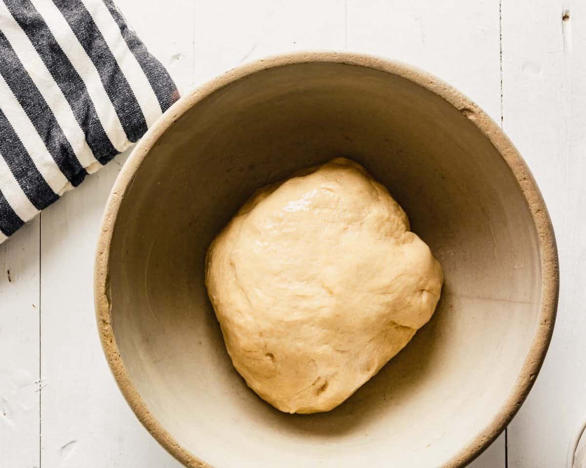 milk bun dough proofing in a stone bowl.