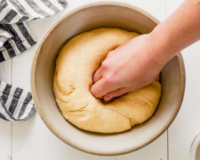 hand punching down dough