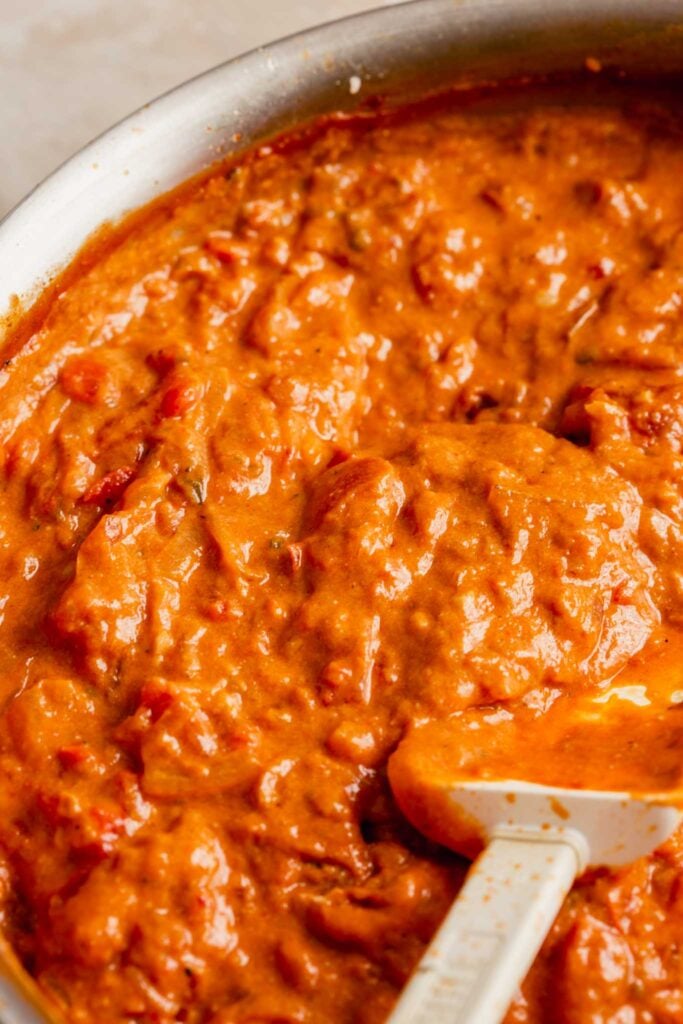 close up image of a bright orange sauce in a skillet