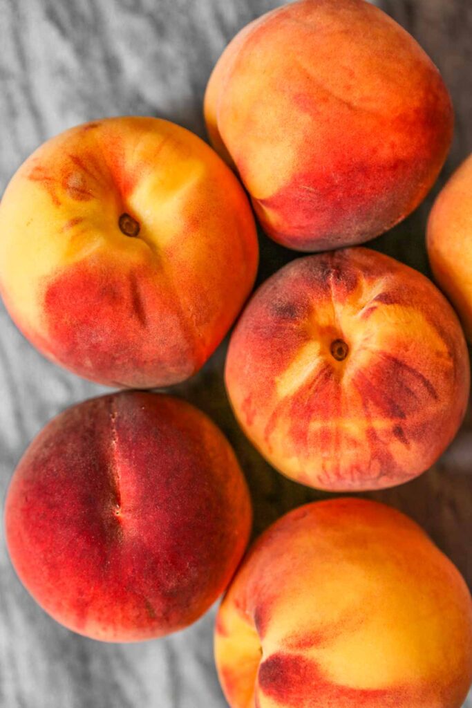 ripe peaches set on a gray marble counter