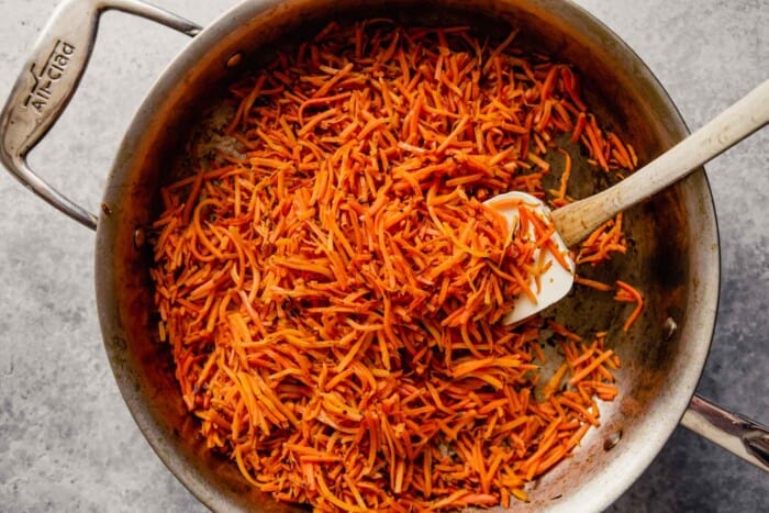 shredded carrots sauteéd in a sauté pan
