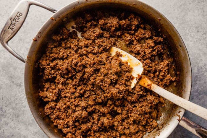 ground beef in a sauté pan with a spatula