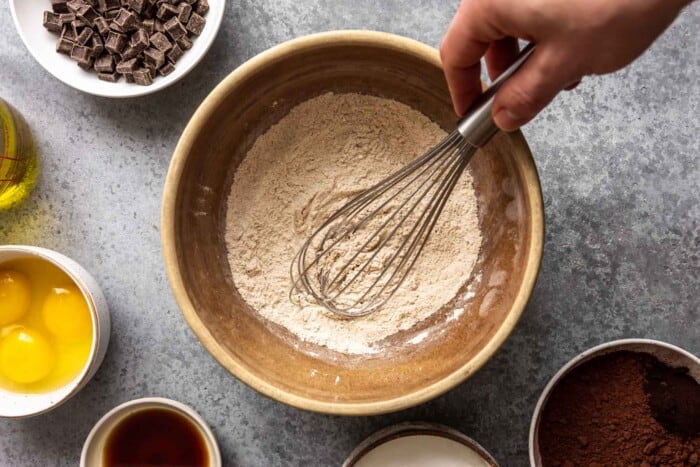 someone whisking flour and leavener in a mixing bowl