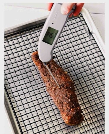 digital instant-read thermometer stuck in a pork tenderloin