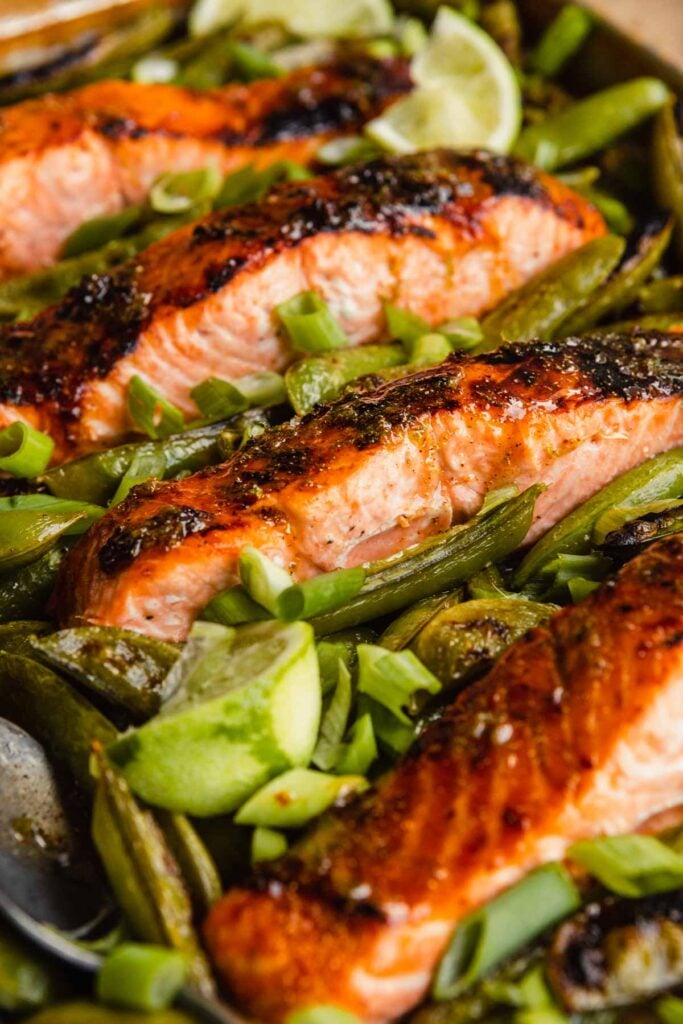 salmon fillet surrounded by snap peas