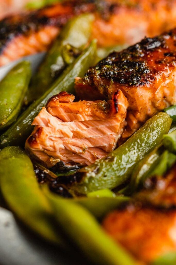 salmon fillet surrounded by snap peas