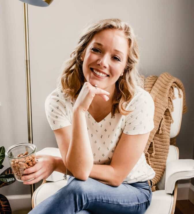 photo of a blonde woman sitting in a chair with a jar of almonds in her hand