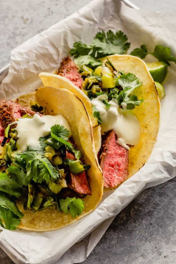steak tacos in small sheet pans lined with parchment paper.
