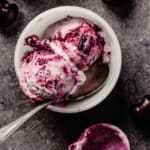 small white bowl with two scoops of cherry ice cream