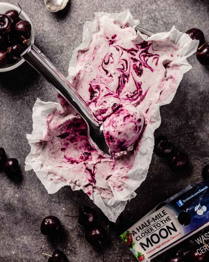 swirled cherry ice cream in a loaf pan with a scoop taken out