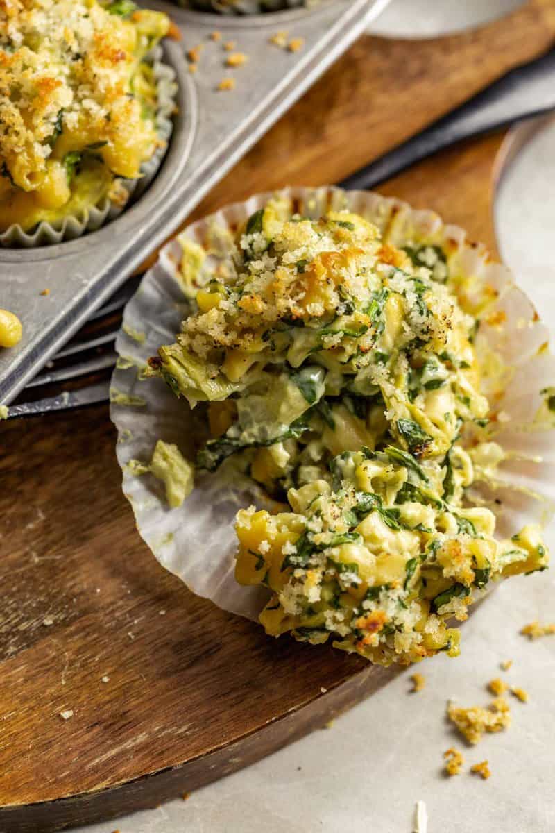 mac and cheese in muffin cups set on a wood board