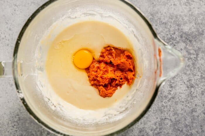mashed sweet potato and an egg on a light batter in a stand mixer