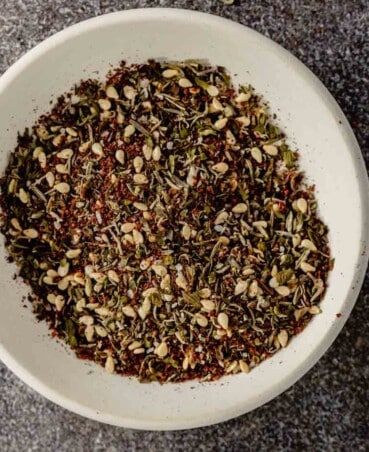 a small white bowl filled with a dried herb and sesame seed spice blend