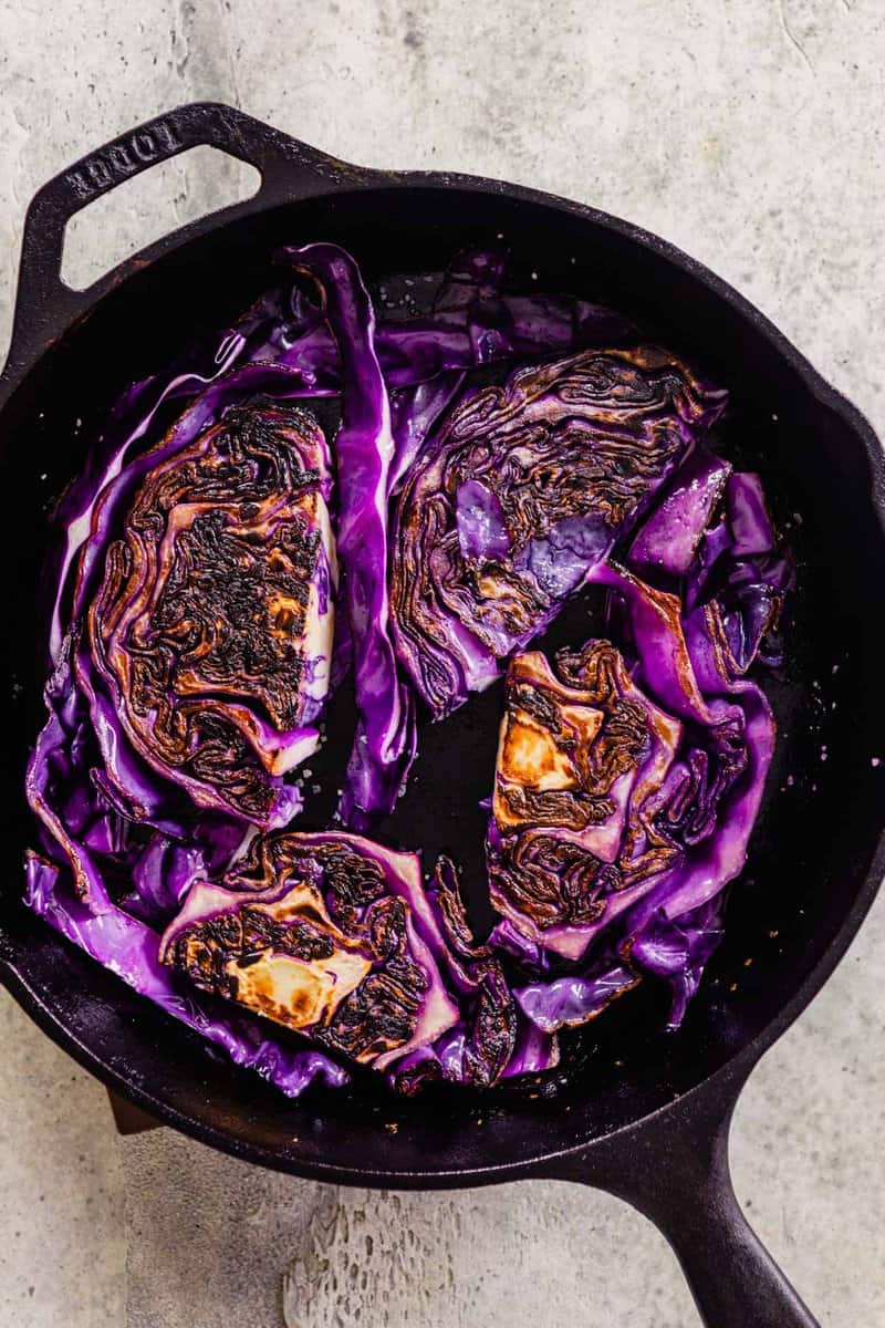 cabbage frying in a cast-iron skillet