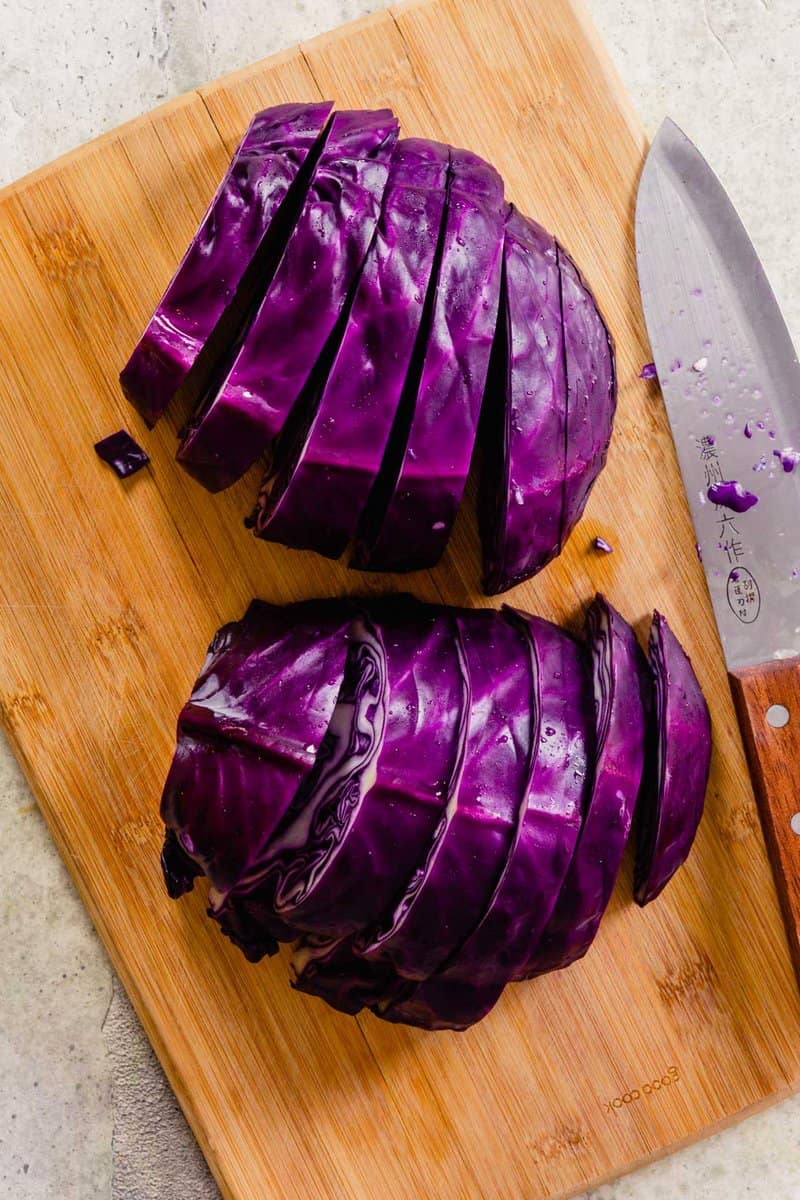 red cabbage cut into thick planks on a wood cutting board