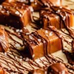 homemade caramel drizzled with chocolate set on a piece of brown parchment paper