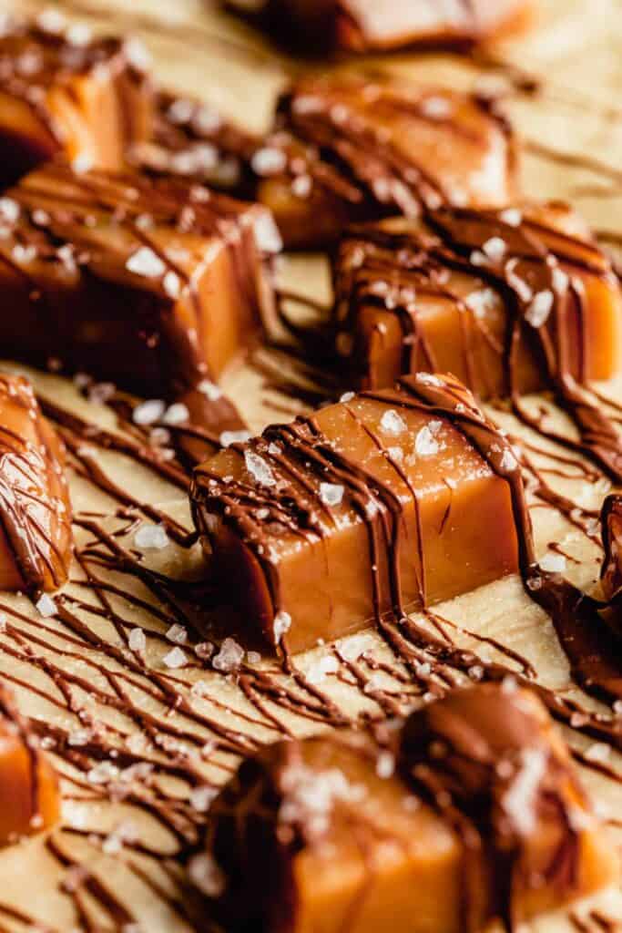 homemade caramel drizzled with chocolate set on a piece of brown parchment paper