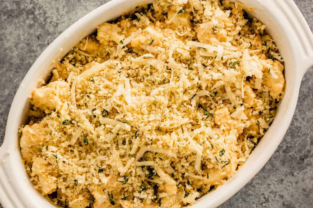 cauliflower in a baking dish topped with breadcrumbs and shredded cheese