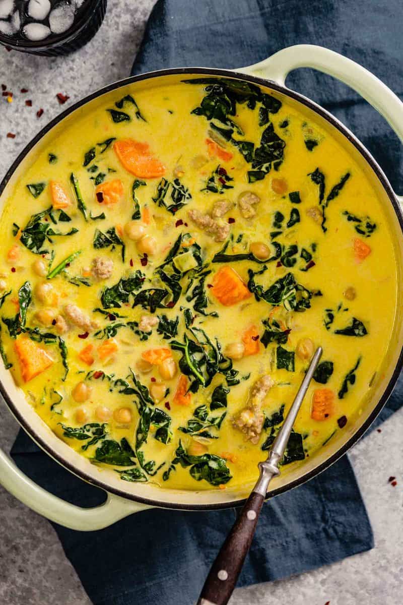 coconut curry soup with kale, chickpeas and sweet potato chunks in a large pot