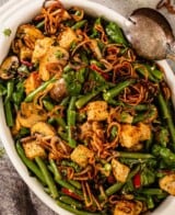 green beans, mushrooms, croutons, and fried onions in an oval white baking dish